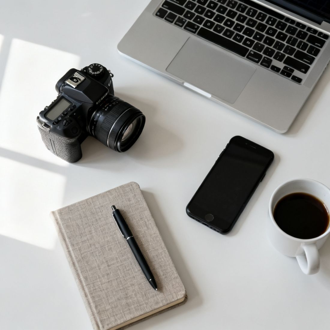 Arbeitsplatz von oben: Notizen, Laptop und Kamera für die Projektanalyse
